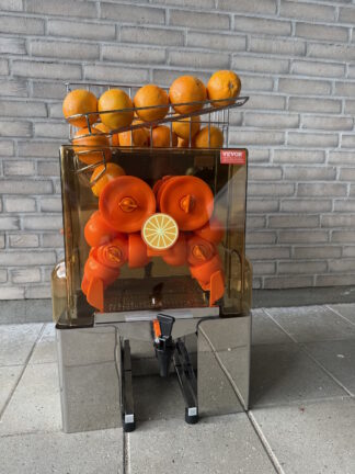 Elektrisk appelsinpresser foran mur